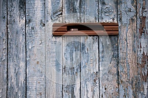 Very old postbox in wheathered wooden fence