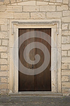 Very old solid door in brick stone wall of castle or fortress of 18th century