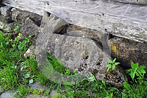 Very old stone cross lying near the foundationat of the wooden church from Poienile Izei, Maramures county.