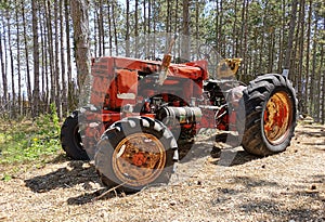 Very old tractor in forest. Red tractor