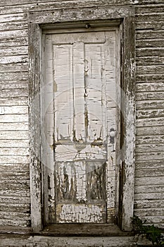 A very old white door with peeling paint