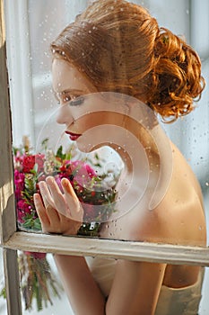 Very pretty sophisticated red-haired girl with a bouquet in his