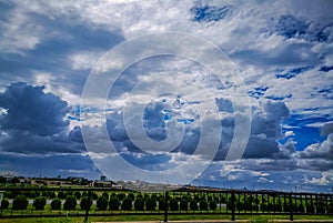 Very prominent storm clouds gather over a lush green garden. Beautiful scenery. photo