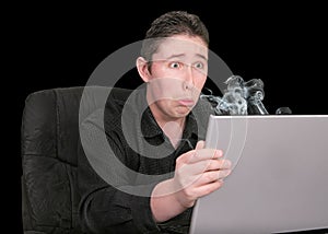 Molto infelice ragazzo guardando il suo fumo computer rotto espressione triste.