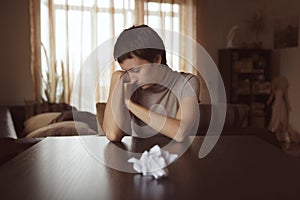 Very sad woman sits in front of crumpled letter