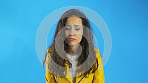 Very sad young woman almost crying in Studio with blue Background.
