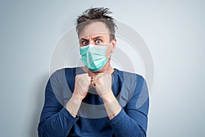 Very scared man in a respiratory mask is afraid of contracting a virus.