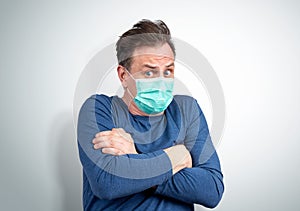 Very scared man in a respiratory mask is afraid of contracting a virus.