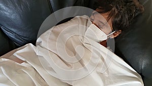 Very sick girl lay down with mask to avoid spread of the virus in her quarantine.