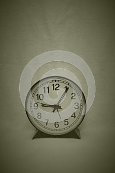 A very simple round black and white clock against empty background