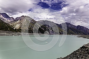 Very small boat in a beautiful turqouise Tasman Glacier Lake and Rocky Mountains of the Mount Cook National Park