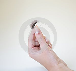 Very small hearing aid in a female hand