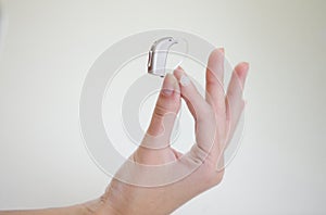 Very small hearing aid in a female hand