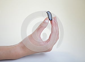 Very small hearing aid in a female hand