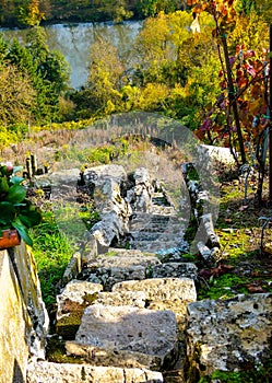 Very steep vineyard staircase made of natural stones with a river in the background