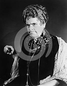 A very stern looking woman holding onto her cane