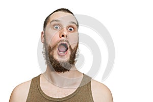 Very surprised scared funny face of a bearded guy with open mouth and big eyes on an isolated background