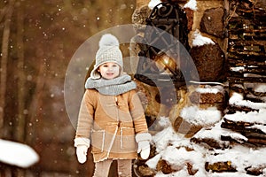 Very sweet beautiful little girl child in the beige coat is on t