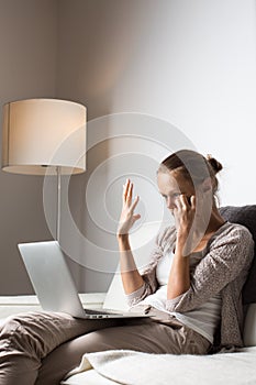 Very tired young woman working late at night on her laptop computer