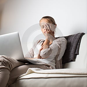 Very tired young woman working late at night on her laptop computer