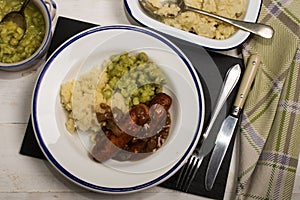 Mashed potato, onion gravey, grilled sausages and mushy peas