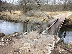 A very unsafe iron bridge over a stream