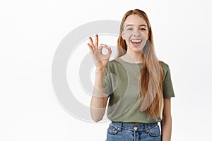 Very well. Laughing happy candid girl, showing okay OK sign and nod in approval, agree, like and praise something good