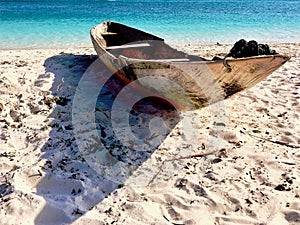 Wooden fishing boat on the beach in the sand photo
