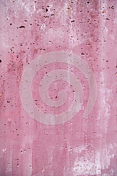 Vesicular rough holey porous stained pink magenta wall close-up