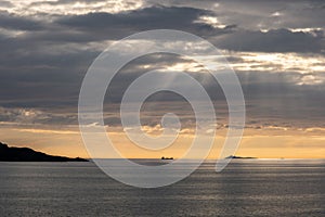 Vestland. Beautiful scenery of a cargo boat in the calm sea at the sunset in a cloudy day
