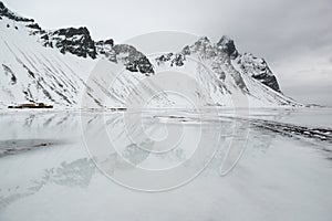 Vestrahorn mountains with reflection in the frozen water, Stokksnes Peninsula in winter, Iceland