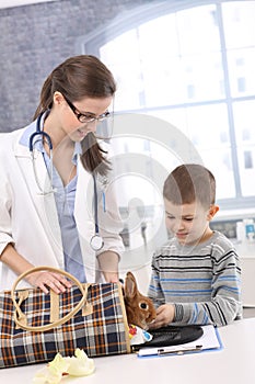 Vet and kid taking rabbit out of carrier