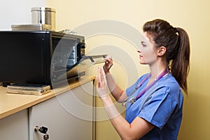 Vet sterilizing medical instruments in special camera.