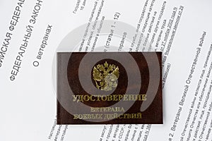 Veteran ID card on the background of the text of the federal law of the Russian Federation
