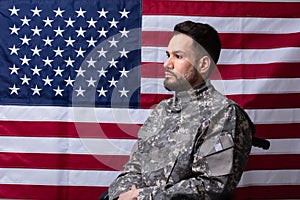 Veteran Sitting In Wheelchair In Front Of An American Flag