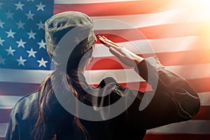 Veterans Day, Memorial Day, Independence Day. A female soldier salutes against the background of the American flag. Copy space.