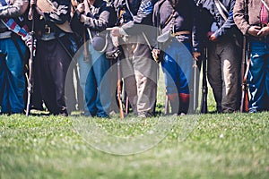 Veterans with guns standing in a row in a field reenacting the American Civil War. photo