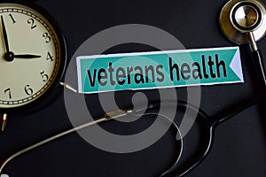 Veterans Health on the print paper with Healthcare Concept Inspiration. alarm clock, Black stethoscope.