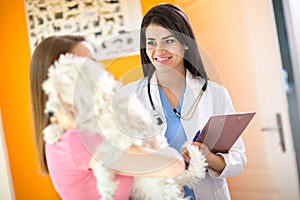 Veterinarian advising a girl about her Maltese dog in vet clinic