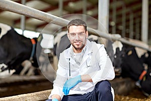 Veterinarian and cows in cowshed on dairy farm