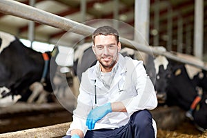 Veterinarian and cows in cowshed on dairy farm photo