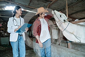 a veterinarian wearing a uniform with a rancher standing near the cows