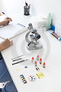 veterinarian writing clipboard with microscope medical equipments laboratory desk. High quality photo