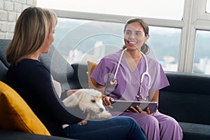 Veterinary With Dog Owner And Pet During Home Visit