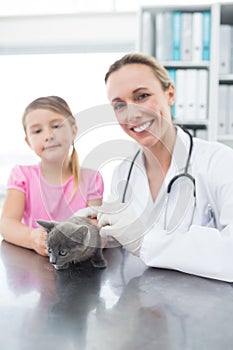 Veterinary and girl with kitten in clinic photo