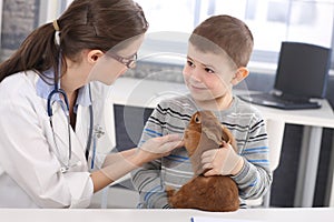 Veterinary and kid discussing rabbit treatment