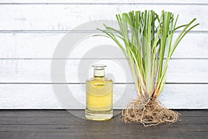 Vetiver grass or chrysopogon zizanioides and oil on an old wooden background photo