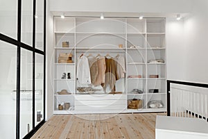 Vew on open space minimalistic scandinavian white wood walk in closet and wardrobe in neutral beige colors