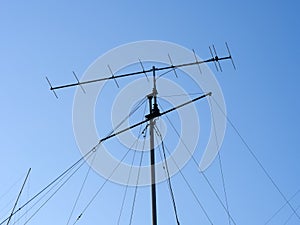 VHF radio antenna with stay ropes against a blue sky photo