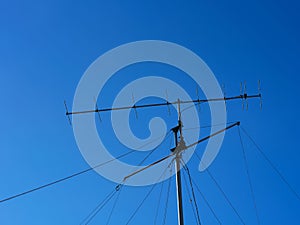 VHF radio antenna with stay ropes against blue sky photo